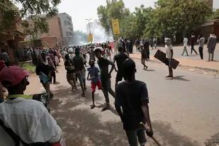 ARCHIVO - Manifestantes chocan con fuerzas de seguridad, que lanzan gas lacrimógeno para evitar que marchen hacia el palacio presidencial, en manifestaciones para reclamar un gobierno civil, en Jartum, Sudán, el 19 de mayo de 2022. (AP Foto/Marwan Ali, Archivoe)