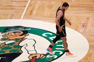 Stephen Curry, de los Warriors de Golden State, cojea sobre la cancha en el tercer partido de las Finales de la NBA ante los Celtics de Boston, el miércoles 8 de junio de 2022 (AP Foto/Michael Dwyer)