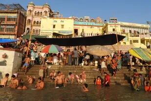 En una ciudad que no descansa, las cenizas de los muertos son entregadas al Ganges mientras el cielo se cubre de barriletes. En la imagen, los peregrinos se bañan en las aguas sagradas del río