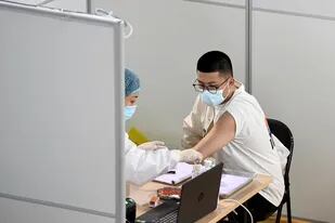 Esta foto tomada el 10 de abril de 2021 muestra a un hombre recibiendo una vacuna contra el coronavirus en Nanjing, en la provincia oriental china de Jiangsu
