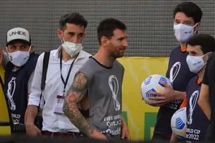 Messi, con la pechera de reportero gráfico: misterio develado. Atrás, de camisa, el dueño de esa vestimenta...