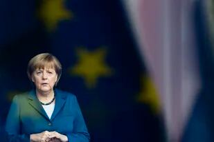 En esta foto de archivo del 3 de junio de 2013, la canciller alemana Angela Merkel está detrás de una ventana que refleja la bandera de la Unión Europea
