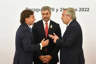 El presidente uruguayo Luis Lacalle Pou habla con Alberto Fernández, detrás el presidente paraguayo Mario Abdo Benítez durante la Cumbre del Mercosur en Luque, Paraguay