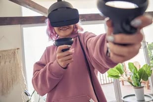 Una joven con un visor de realidad virtual de Oculus, una firma tecnológica que forma parte de Meta, la compañía liderada por Mark Zuckerberg que apuesta fuerte a los desarrollos de realidad aumentada y mixta