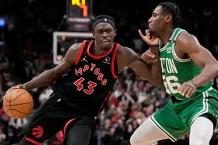 Pascal Siakam (43), de los Raptors de Toronto, lleva el balón con la marca de Aaron Nesmith (26), de los Celtics de Boston, durante la segunda mitad del juego de baloncesto de la NBA, en Toronto, el lunes 28 de marzo de 2022. (Frank Gunn/The Canadian Press vía AP)
