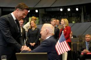 El presidente estadounidense Joe Biden, al centro, saluda al primer ministro holandés Mark Rutte, a la izquierda, durante una cumbre de la OTAN el jueves 24 de marzo de 2022, en su sede en Bruselas. (AP Foto/Markus Schreiber)