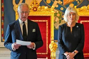 El rey británico Carlos III, flanqueado por la reina consorte Camilla, pronuncia un discurso tras recibir un mensaje de condolencia por la muerte de su madre, la reina Isabel II, en el castillo de Hillsborough, en Belfast, el 13 de septiembre de 2022, durante su visita a Irlanda del Norte.