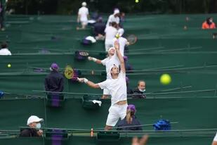 Las canchas de tenis en Roehampton, Londres, un sitio especial donde se juega la qualy de Wimbledon; en primer plano, lanzando la pelota antes de sacar, el argentino Juan Pablo Ficovich.