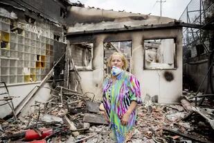 Una mujer del pueblo costero de Mati, frente a su casa destrozada por los incendios forestales