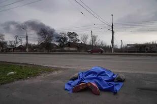 Un cadáver cubierto por una lona yace en una calle en Mariúpol, Ucrania, el 7 de marzo del 2022. (AP Foto/Evgeniy Maloletka)
