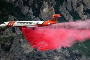 Un avión bombero lanza espuma retardante sobre el incendio forestal que se desató en Springville, Utah