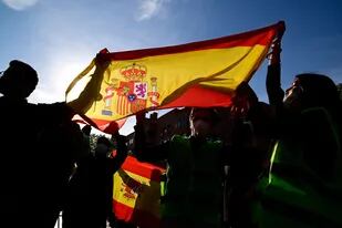 En esta foto de archivo tomada el 7 de abril de 2021, simpatizantes del partido de extrema derecha Vox sostienen una bandera española durante la presentación del candidato de Vox para las elecciones regionales de Madrid en el suburbio madrileño de Vallecas. - El derechista Partido Popular (PP) ganó el 13 de febrero de 2022 en Castilla y León, en el centro de España, en unas elecciones regionales anticipadas marcadas por un fuerte ascenso del partido de extrema derecha Vox.