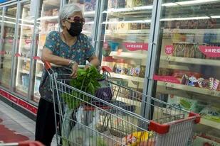 Una mujer compra alimentos en un supermercado de Beijing, en China