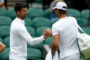 Saludo de leyendas: el serbio Novak Djokovic y el español Rafael Nadal, durante una sesión de entrenamiento en la cancha central de Wimbledon, antes del arranque del tercer grande del año.