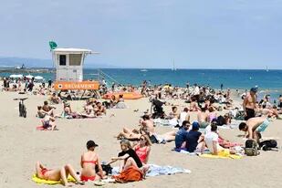 La gente toma el sol en la playa del Bogatell, en Barcelona