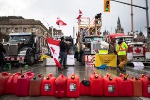 Camioneros y simpatizantes bloquean un acceso en el Puente Ambassador que une a Detroit con Windsor, en protesta contra los mandatos de vacunas y restricciones relacionadas con el COVID-19 en Windsor, Ontario, el viernes 11 de febrero de 2022. (Nathan Denette/The Canadian Press via AP)