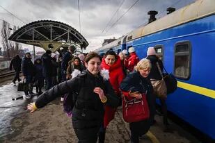 Madres con niños y niñas ucranianos tratan de abordar un tren en la ciudad de Irpin, mientras escuchan los disparos y las bombas de los ejércitos rusos y ucranianos