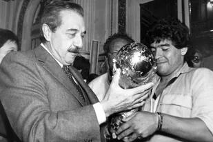 Diego Maradona le muestra a Raúl Alfonsín la copa obtenida en el Mundial 1986