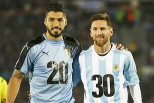 Luis Suárez y Lionel Messi, con las camisetas de promoción para el Mundial 2030 en un partido de Eliminatorias en 2019