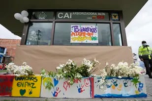 Mensajes escritos en español a favor de la paz están afuera de una estación de policía que fue atacada con una bomba en el lado sur de Bogotá, Colombia, el lunes 28 de marzo de 2022. Según la policía, dos niños murieron el sábado por la noche cuando una bomba explotó en la pared trasera. (AP Foto/Fernando Vergara)