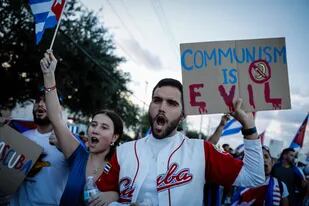 "El comunismo es el diablo", dice un cartel en una marcha para apoyar a los manifestantes cubanos en Florida