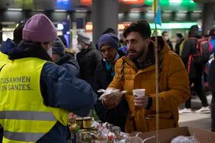 Refugiados llegados de Ucrania reciben asistencia en la estación de trenes de Berlín el 3 de marzo del 2022. Con frecuencia, la gente que le escapa a los rusos tras la invasión de Ucrania son refugiados que ya le había huido previamente a la violencia en sus países de origen. Hay incluso personas que se han visto desplazadas por tercera vez. (Paul Zinken/dpa vía AP, File)