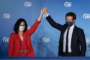 Archivo - La conservadora presidenta de la Comunidad de Madrid, Isabel Díaz Ayuso, y el líder del Partido Popular, Pablo Casado, saludan frente a la sede del partido el 4 de mayo de 2021, en Madrid. (AP Foto/Bernat Armangue, Archivo)