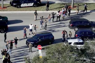 ARCHIVO - Varios estudiantes levantan los brazos mientras son evacuados por la policía de la escuela secundaria Marjory Stoneman Douglas en Parkland, Florida, el 14 de febrero de 2018, después de que un hombre armado abriera fuego en el plantel. (Mike Stocker/South Florida Sun-Sentinel vía AP, archivo)