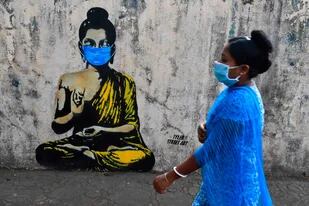 Un grafitti de Buddha con una barbijo en Mumbai