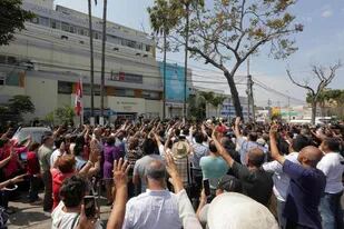 Simpatizantes del expresidente García cantaron ayer el himno peruano frente al hospital en el que murió, en Lima