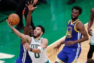 Jayson Tatum, de los Celtics de Boston, encesta frente a Draymond Green, de los Warriors de Golden State, en el sexto partido de las Finales de la NBA, el jueves 16 de junio de 2022 (AP Foto/Michael Dwyer)