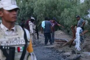 Voluntarios drenan agua de una mina de carbón inundada donde varios mineros quedaron atrapados el jueves 4 de agosto de 2022, en Sabinas, en el estado mexicano de Coahuila. (AP Foto/Alfredo Lara)