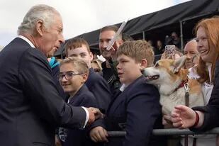 El rey británico Carlos III saluda a los asistentes a su llegada al castillo de Hillsborough, en Belfast, el 13 de septiembre de 2022, durante su visita a Irlanda del Norte.