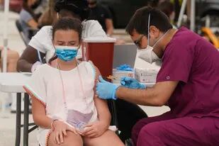 Una niña de 12 años recibe su primera dosis de la vacuna de Pfizer contra el COVID-19 aplicada por el enfermero Jorge Tase en Miami Beach, Florida