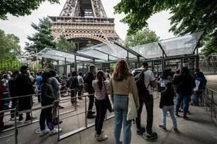 Los visitantes hacen fila para poder visitar la Torre Eiffel en París