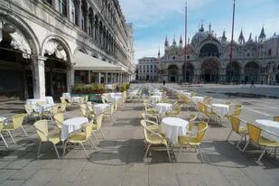 Sillas y mesas vacías se alinean afuera de un restaurante en la Plaza de San Marcos en Venecia, Italia, el lunes 9 de marzo de 2020