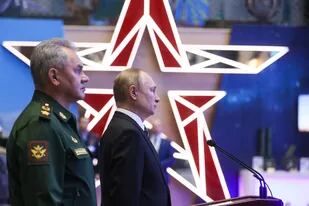El presidente ruso Vladimir Putin y el ministro de Defensa Sergei Shoigu recorren una exhibición de equipo militar antes de la reunión anual de la junta del Ministerio de Defensa en Moscú el 21 de diciembre de 2021.