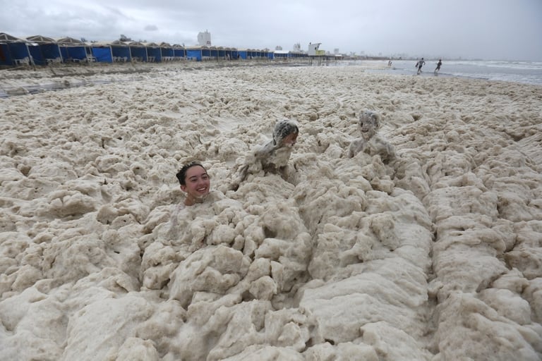 Turistas juegan en con extraña espuma que cubre las playas de Punta Mogotes
Foto: Mauro V. Rizzi