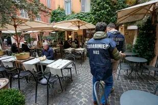 Un fripo de policías controlan los súper green pass en una zona de restaurantes en Roma, Italia