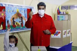 El presidente de Venezuela, Nicolás Maduro, muestra su voto acompañado de su nieta
