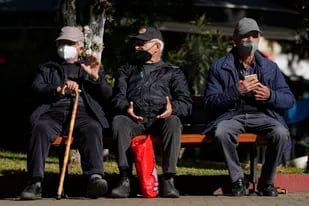 ARCHIVO - Tres ancianos con mascarillas para combatir los contagios de coronavirus, sentados en un banco en Atenas, Grecia, el lunes 3 de enero de 2022. (AP Foto/Thanassis Stavrakis, Archivo)