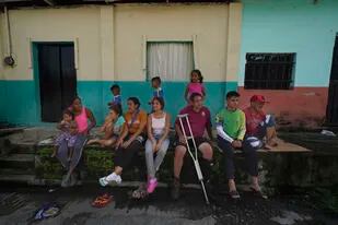 El migrante venezolano Jesús González, con una sola muleta, se sienta con su familia, que forma parte de una caravana migrante que se detuvo a descansar en Huixtla, estado de Chiapas, México, el miércoles 8 de junio de 2022. (AP Foto/Marco Ugarte)