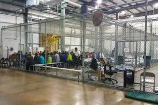 Las autoridades publicaron esta imagen de inmigrantes dentro de una gran jaula: los periodistas dijeron que vieron a niños no acompañados en condiciones similares.