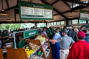Los espectadores visitan un puesto de concesiones durante el Masters de Augusta