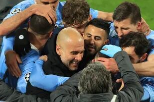 Guardiola, en el medio de los abrazos de los jugadores de Manchester City, que volvió a consagrrse campeón de la Prremier League.