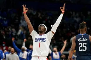 Reggie Jackson, base de los Clippers de Los Ángeles, festeja luego de anotar un triple ante los Mavericks de Dallas, el sábado 12 de febrero de 2022 (AP Foto/LM Otero)