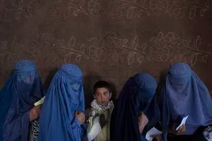 En esta imagen de archivos, mujeres afganas esperan para recibir dinero en efectivo en un punto de distribución gestionado por el Programa Mundial de Alimentos, en Kabul, Afganistán, el 20 de noviembre de 2021. (AP Foto/Petros Giannakouris, archivo)
