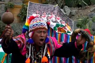 Un chamán peruano realiza un ritual de buena suerte frente a un foto de la selección peruana de fútbol, en el cerro de San Cristóbal en Lima, el viernes 10 de junio de 2022. (AP Foto/Martín Mejía)