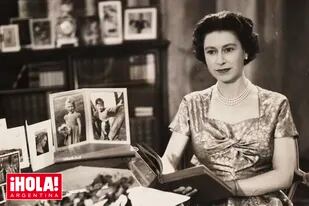 EN LA PANTALLA. En 1957, en Sandringham y rodeada de fotos familiares, Su Majestad protagoniza la primera transmisión navideña televisada.