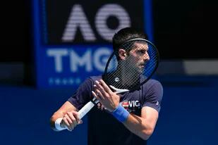 ARCHIVO - El defensor del título masculino del Abierto de Australia, Novak Djokovic, entrena en la cancha Rod Laver antes del torneo en Melbourne, Australia, el 12 de enero de 2022. (AP Foto/Mark Baker, Archivo)